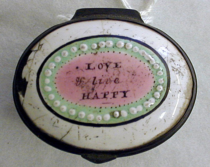 Enamel box with white, pink and green oval decoration, including the typical circle of white dots, with the motto in the centre.