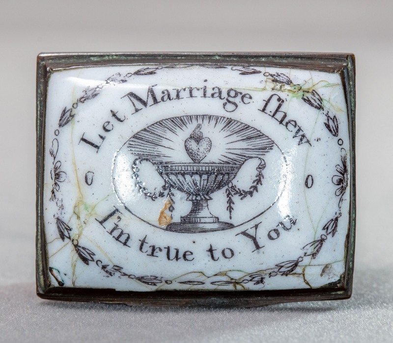 White, rectangular enamel box with black decoration. An urn with a heart above it, surrounded by the motto.