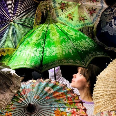 A woman's head in profile, viewed through a sea of open parasols